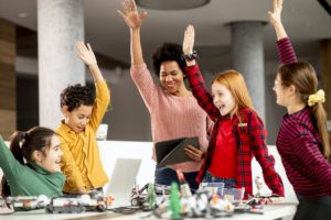 happy kids with their African American female science teacher with laptop