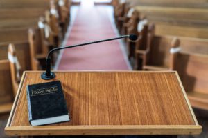 View of church pulpit with bible on it, overlooking the church